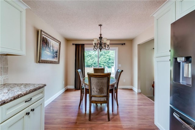 40 Phyllis Ln, Hastings, NY 13076 - dining room with a chandelier, a textured ceiling, and wood finished floors