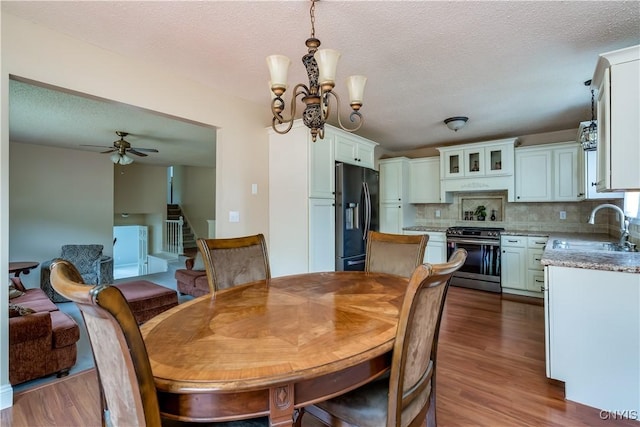 40 Phyllis Ln, Hastings, NY 13076 - dining room with wood finished floors, stairs, a chandelier, a ceiling fan, and a textured ceiling