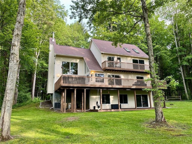 735 Howell Rd, Conquest, NY 13140 - back of property with a shingled roof, a deck, and a lawn