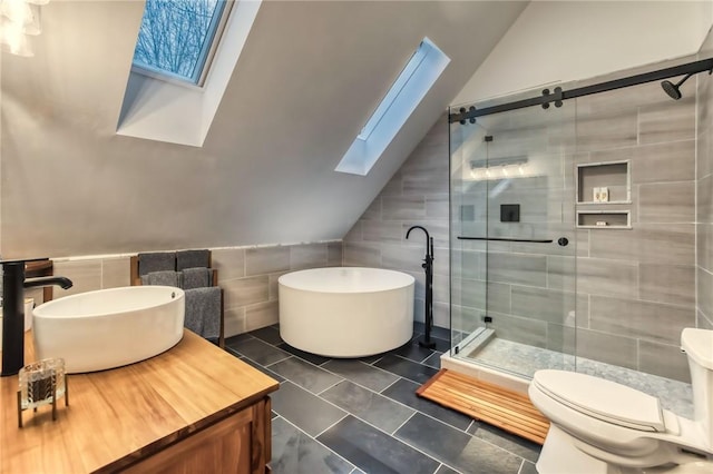 735 Howell Rd, Conquest, NY 13140 - bathroom with a skylight, vaulted ceiling, tile walls, a stall shower, and a freestanding tub