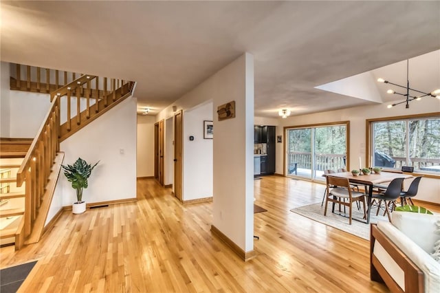 735 Howell Rd, Conquest, NY 13140 - foyer with light wood-type flooring, stairs, and a chandelier