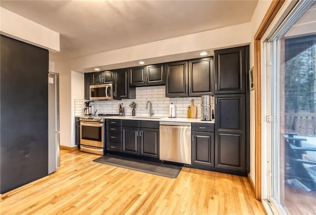 735 Howell Rd, Conquest, NY 13140 - kitchen with stainless steel appliances, light wood-style floors, decorative backsplash, and light countertops