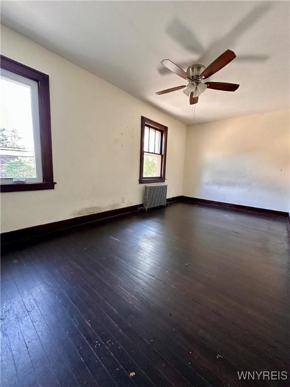2010 Niagara St, Niagara Falls, NY 14303 - unfurnished room featuring radiator heating unit, wood-type flooring, and a ceiling fan