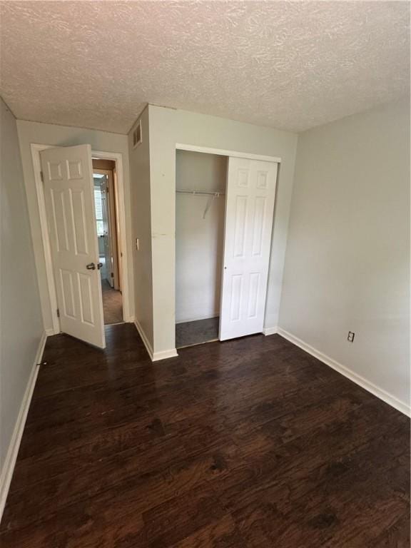 94 Brookhaven, Rochester, NY 14621 - unfurnished bedroom featuring dark wood-type flooring, a textured ceiling, and a closet
