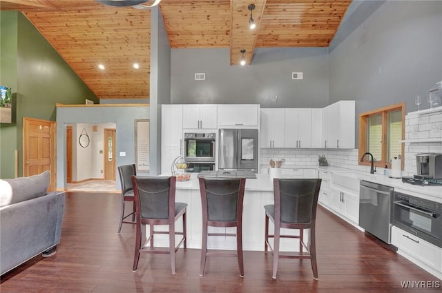 2328 Gowanda Zoar Rd, Collins, NY 14070 - kitchen with appliances with stainless steel finishes, high vaulted ceiling, wooden ceiling, a kitchen breakfast bar, and tasteful backsplash
