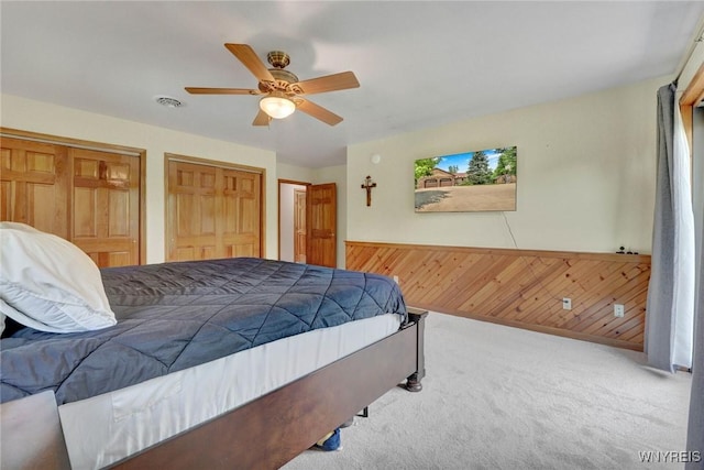 2328 Gowanda Zoar Rd, Collins, NY 14070 - bedroom with two closets, carpet floors, wainscoting, wood walls, and a ceiling fan