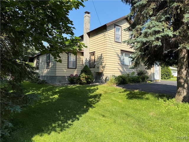5130 Onondaga Rd, Onondaga, NY 13215 - view of home's exterior with a chimney, a yard, and asphalt driveway