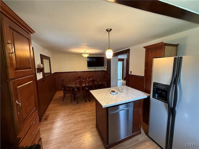 5130 Onondaga Rd, Onondaga, NY 13215 - kitchen featuring stainless steel appliances, wainscoting, light wood-style floors, hanging light fixtures, and light stone countertops
