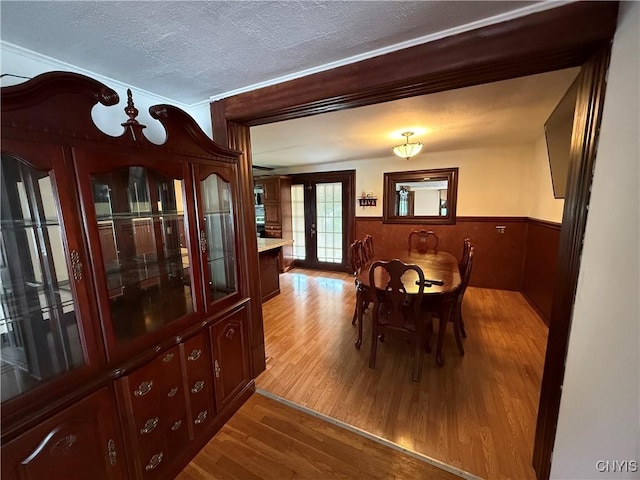5130 Onondaga Rd, Onondaga, NY 13215 - dining room with wood finished floors, wainscoting, a textured ceiling, and wood walls