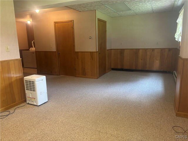 36 Lee Rd, Dryden, NY 13053 - empty room featuring a wainscoted wall, washer / dryer, wooden walls, a baseboard radiator, and carpet floors