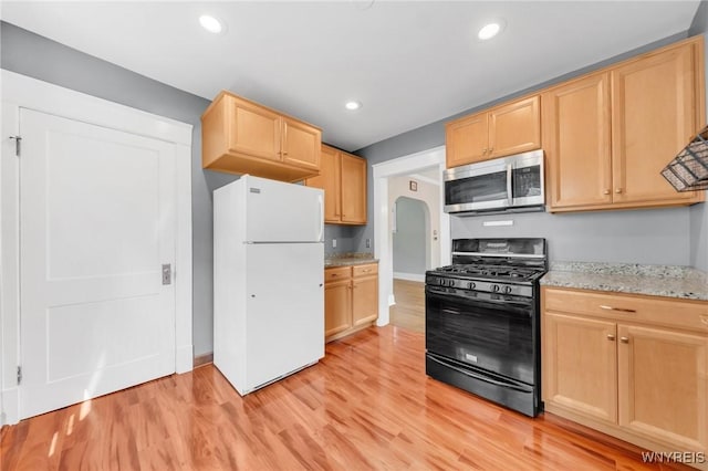 315 Westfield Rd N, Amherst, NY 14226 - kitchen featuring stainless steel appliances, light brown cabinetry, light wood-style flooring, arched walkways, and light stone counters