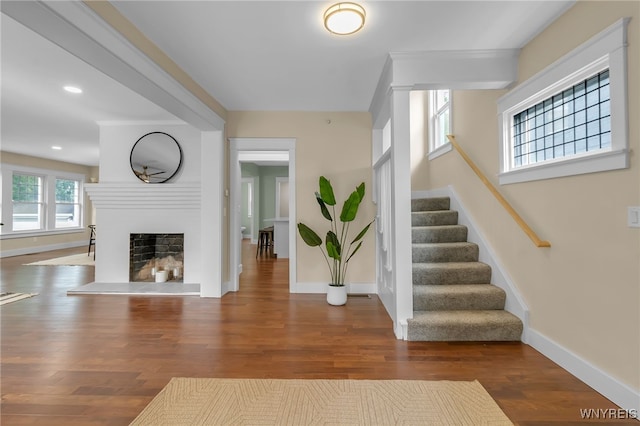 64 Sagamore Ter, Buffalo, NY 14214 - entryway featuring stairway, a fireplace with raised hearth, wood finished floors, and recessed lighting