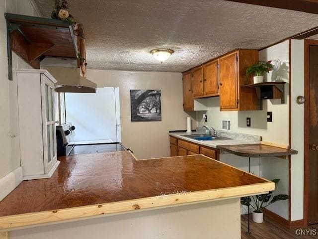 1086 Sweatman Ave, Oneida-Inside, NY 13421 - kitchen featuring brown cabinets, ventilation hood, open shelves, freestanding refrigerator, and a textured ceiling