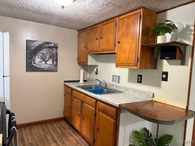 1086 Sweatman Ave, Oneida-Inside, NY 13421 - kitchen featuring open shelves, brown cabinets, light wood-type flooring, range, and a textured ceiling