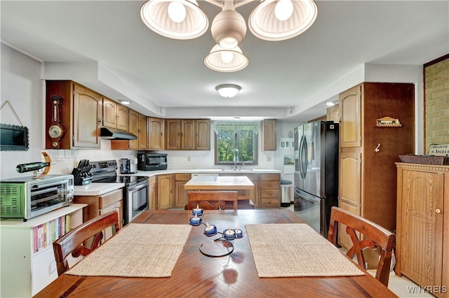 3738 Forks Rd, Yorkshire, NY 14134 - kitchen with appliances with stainless steel finishes, light countertops, decorative backsplash, light wood finished floors, and under cabinet range hood