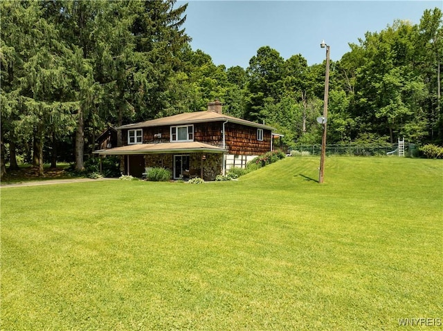 3738 Forks Rd, Yorkshire, NY 14134 - view of front of house with a front lawn, a chimney, and a view of trees