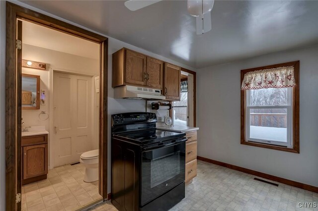 14328 Pearl St, Diana, NY 13648 - kitchen featuring electric range, under cabinet range hood, ceiling fan, light countertops, and brown cabinetry