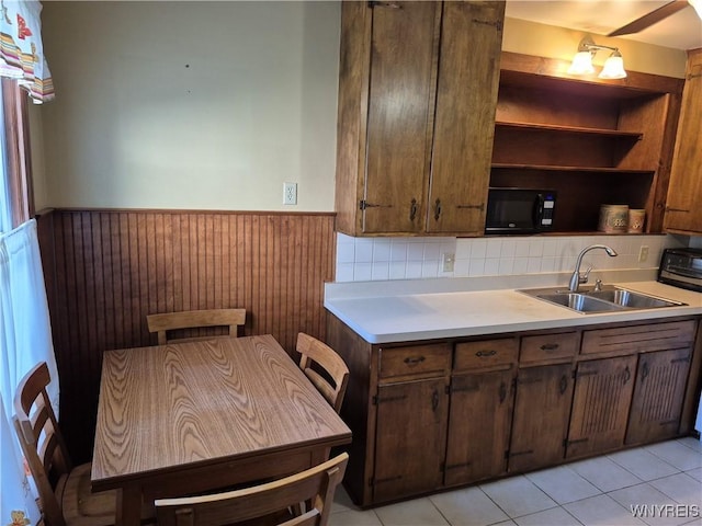 359 Utica St, Tonawanda-City, NY 14150 - kitchen with black microwave, wainscoting, light countertops, open shelves, and light tile patterned flooring