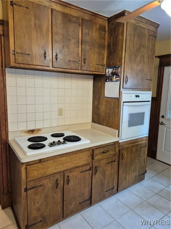 359 Utica St, Tonawanda-City, NY 14150 - kitchen featuring white appliances, light countertops, decorative backsplash, and light tile patterned floors