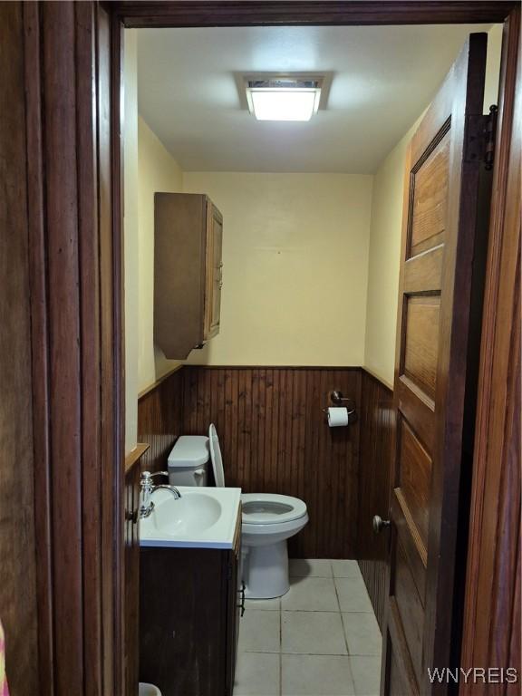 359 Utica St, Tonawanda-City, NY 14150 - bathroom with wainscoting, vanity, tile patterned floors, and wooden walls