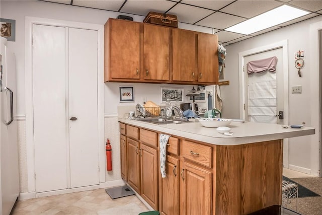 21 Washington St, Greene, NY 13778 - kitchen featuring light countertops, light flooring, brown cabinets, a paneled ceiling, and a peninsula