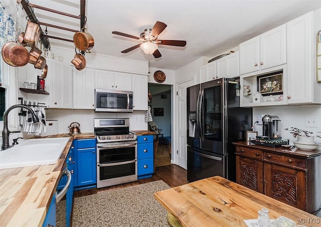 5458 Oxbow Rd, Cazenovia, NY 13035 - kitchen with appliances with stainless steel finishes, butcher block counters, blue cabinetry, and white cabinetry