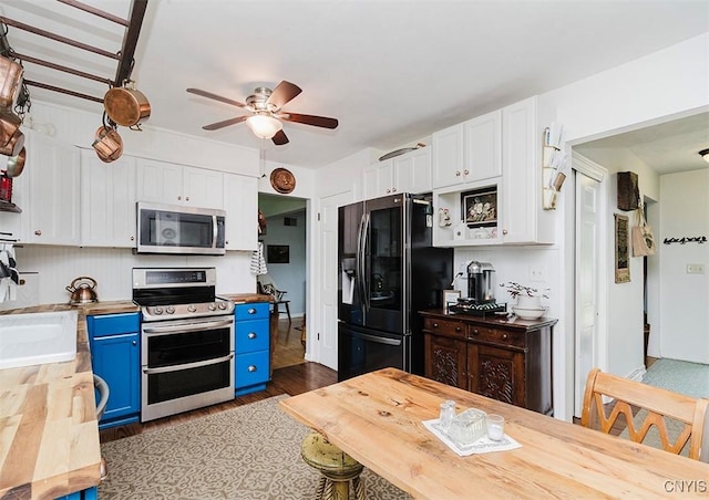 5458 Oxbow Rd, Cazenovia, NY 13035 - kitchen with stainless steel appliances, blue cabinets, butcher block counters, and white cabinetry