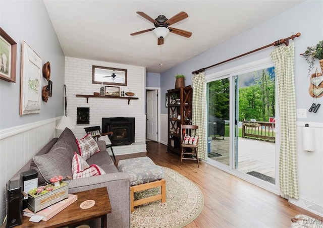 5458 Oxbow Rd, Cazenovia, NY 13035 - living area with a fireplace, a ceiling fan, a wainscoted wall, and wood finished floors