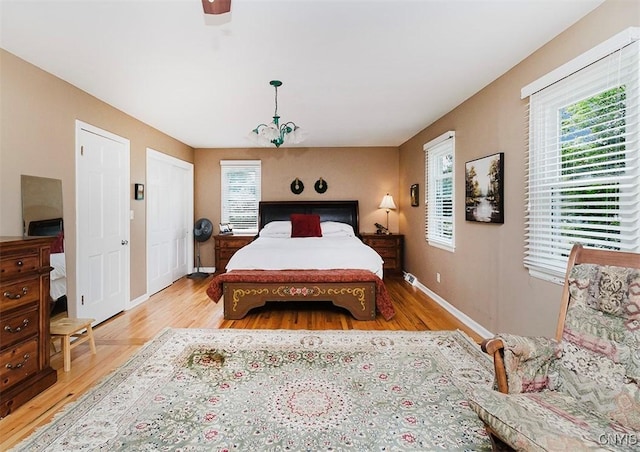 5458 Oxbow Rd, Cazenovia, NY 13035 - bedroom featuring multiple windows, wood finished floors, and a ceiling fan