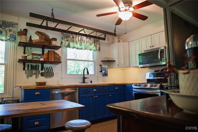 5458 Oxbow Rd, Cazenovia, NY 13035 - kitchen featuring blue cabinets, appliances with stainless steel finishes, wood counters, open shelves, and ceiling fan