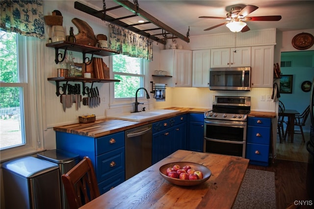 5458 Oxbow Rd, Cazenovia, NY 13035 - kitchen with blue cabinetry, wooden counters, stainless steel appliances, and open shelves