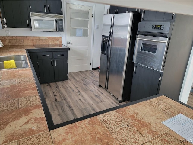 1665 State Route 31, Sullivan, NY 13037 - kitchen featuring stainless steel appliances, dark cabinetry, light countertops, and light wood finished floors