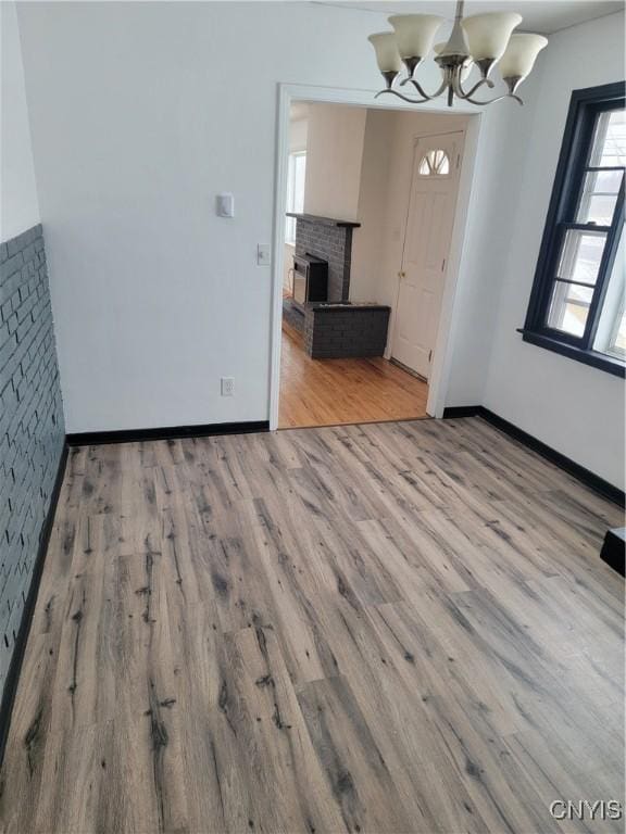 1665 State Route 31, Sullivan, NY 13037 - unfurnished dining area with wood finished floors, a chandelier, and a brick fireplace