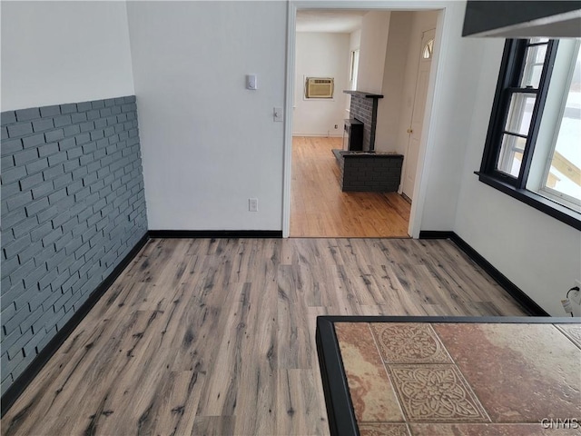 1665 State Route 31, Sullivan, NY 13037 - empty room featuring wood finished floors, a brick fireplace, and a wall unit AC
