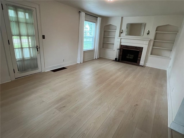 119 Platt St, Erwin, NY 14870 - unfurnished living room with wood finished floors, built in shelves, and a fireplace
