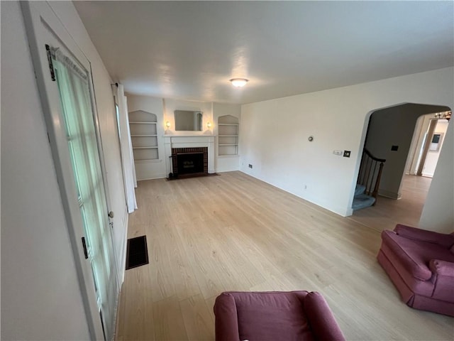 119 Platt St, Erwin, NY 14870 - living area featuring light wood-style flooring, built in shelves, a fireplace, and stairway