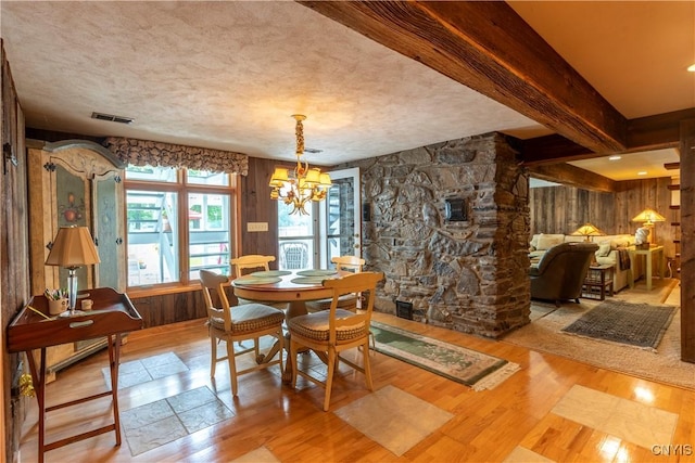1664 S Ivy, Lysander, NY 13027 - dining area featuring wood finished floors, a chandelier, wooden walls, a textured ceiling, and beam ceiling