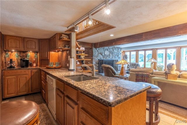 1664 S Ivy, Lysander, NY 13027 - kitchen with white dishwasher, open floor plan, a peninsula, a stone fireplace, and brown cabinets