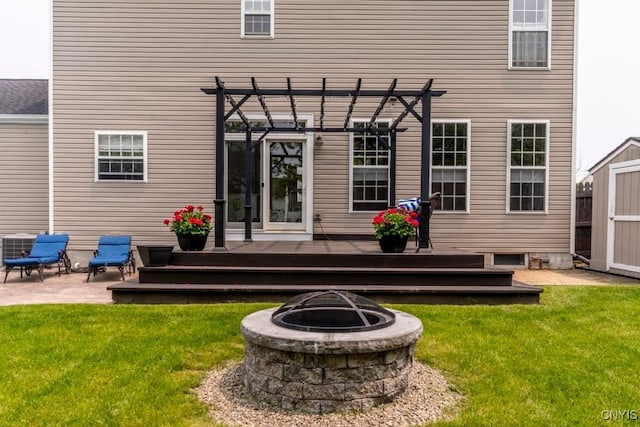 8228 Dampier Cir, Clay, NY 13090 - rear view of property featuring an outdoor fire pit, a wooden deck, a pergola, a shed, and a lawn