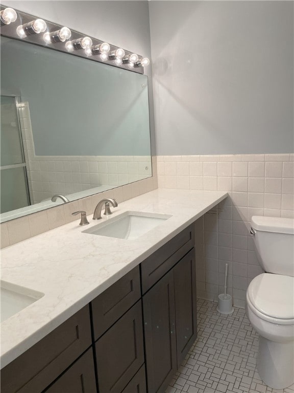 75 Towpath Ln, Brighton, NY 14618 - bathroom with double vanity, tile walls, tile patterned flooring, wainscoting, and a shower with shower door