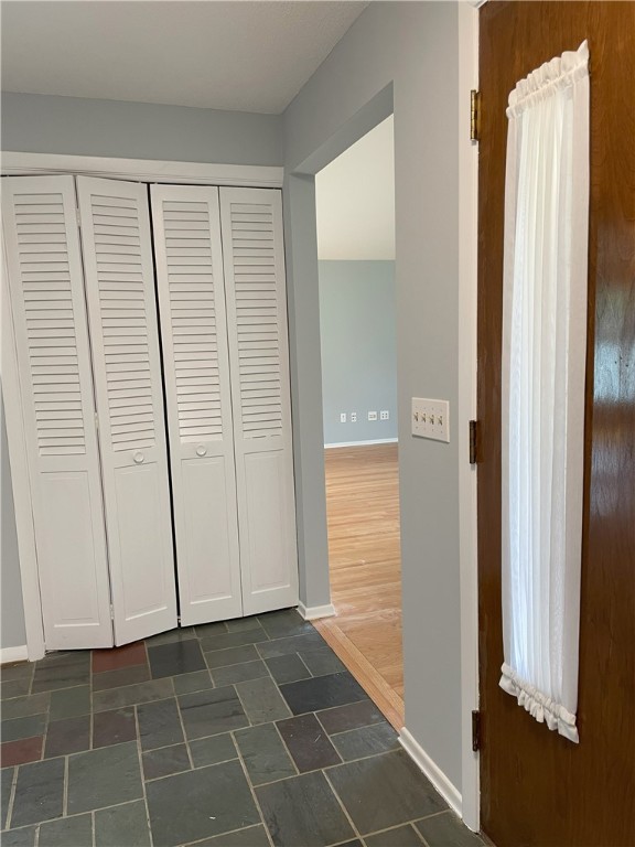 75 Towpath Ln, Brighton, NY 14618 - hallway featuring baseboards and dark stone finish flooring