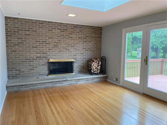 75 Towpath Ln, Brighton, NY 14618 - unfurnished living room with a brick fireplace, wood finished floors, ornamental molding, and french doors