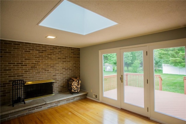 75 Towpath Ln, Brighton, NY 14618 - unfurnished living room with wood finished floors, a textured ceiling, and brick wall