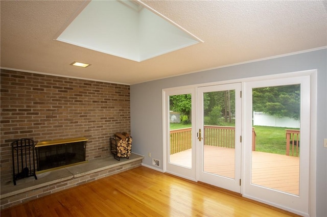 75 Towpath Ln, Brighton, NY 14618 - unfurnished living room with wood finished floors, a brick fireplace, a textured ceiling, and ornamental molding