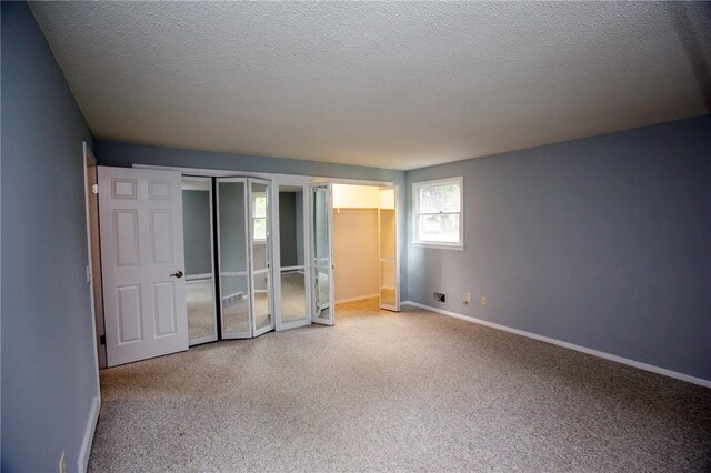 75 Towpath Ln, Brighton, NY 14618 - unfurnished bedroom with carpet, a textured ceiling, and two closets
