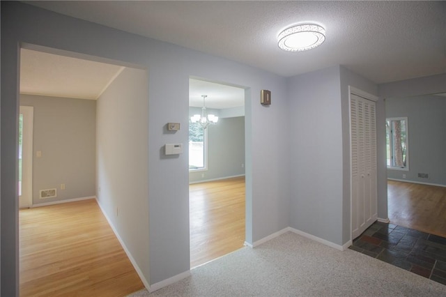 75 Towpath Ln, Brighton, NY 14618 - hall with a chandelier and a textured ceiling