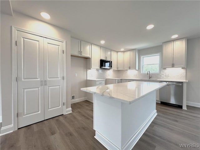 122 Winterbrook Dr, Amherst, NY 14228 - kitchen with appliances with stainless steel finishes, dark wood-style floors, recessed lighting, backsplash, and a center island