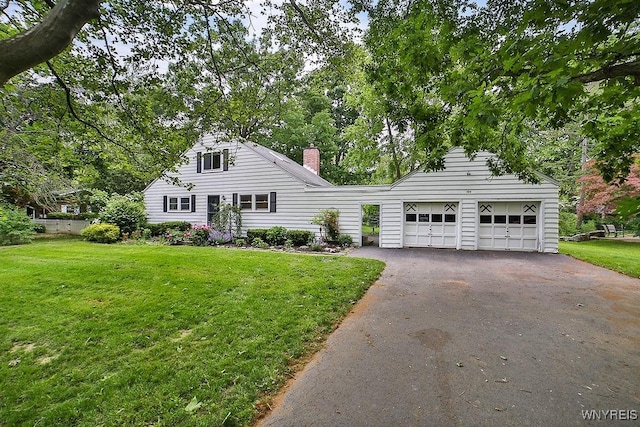 425 Tryon Dr, Lewiston, NY 14092 - view of front of house with asphalt driveway, a front yard, and a chimney