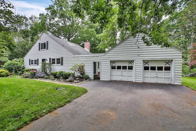 425 Tryon Dr, Lewiston, NY 14092 - view of front of house with a front lawn, asphalt driveway, an attached garage, and a chimney