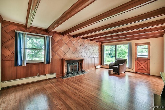 425 Tryon Dr, Lewiston, NY 14092 - unfurnished living room featuring a baseboard radiator, wood finished floors, healthy amount of natural light, a fireplace with flush hearth, and beam ceiling